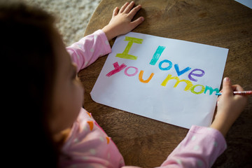 Girl writing love note to mother