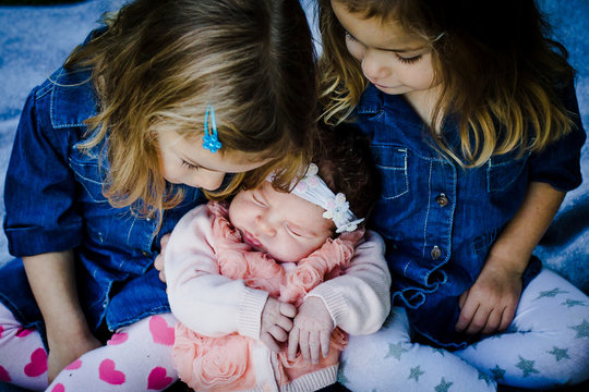 Two Girls Holding Baby Sister