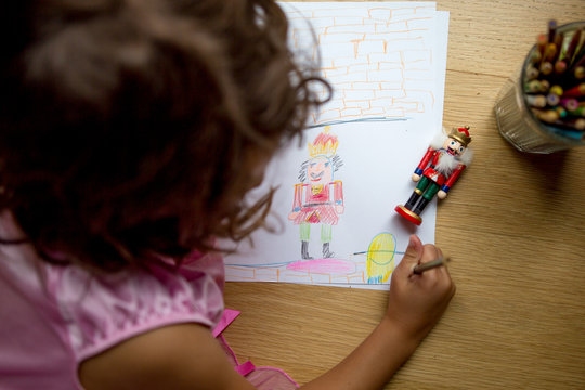 Young girl drawing christmas decoration 