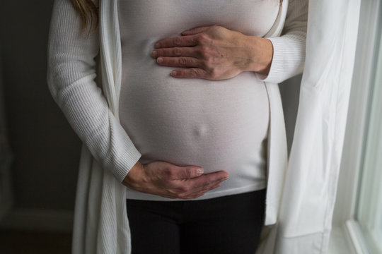 Pregnant woman holding tummy 