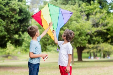 Two boys holding a kite in park