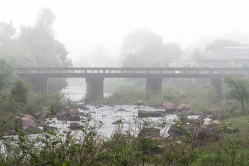 Morning mist lingering over concrete bridge. Nan province, Thailand.