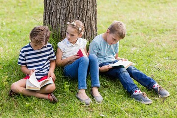 Kids reading books in park