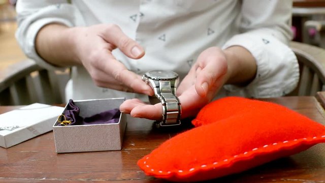 Man receives watch as a present and wears it on a hand
