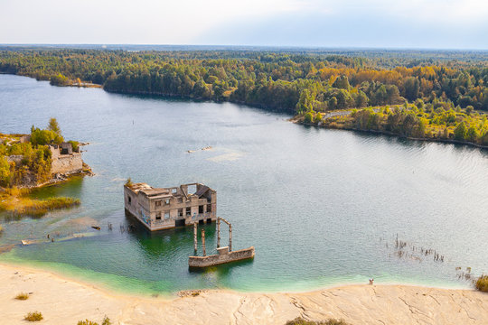 Sand hills of quarry with a pond and abandoned prison in Rummu, Estonia