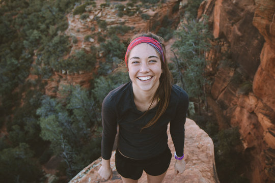 Over head view of young woman standing on a high rock 