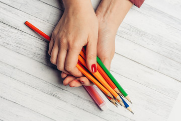 multicolored pencils in hands