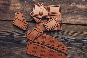 broken dark chocolate on a wooden background