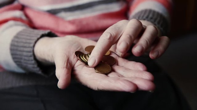 Seniorin mit Kleingeld in der Hand
