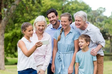 Multi-generation family looking at mobile phone