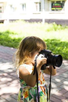 Baby with a photo camera takes pictures.