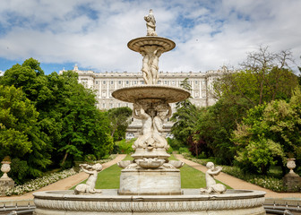 Close up view of a sculpture, with the royal palace of Madrid in