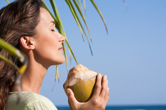 femme avec une noix de coco sous un paimier