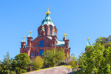 Fototapeta na wymiar Uspenski Cathedral On Hill At Summer Sunny Day. Red Church - Tourist destination In Finnish Capital
