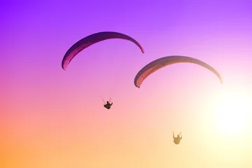 Tuinposter Paragliding on the sunset © kamilpetran