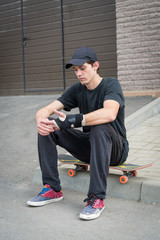 Teenage skateboarder sitting