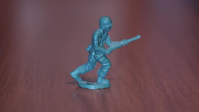 Toy green soldier with a gun on a dark background made of plastic American Military