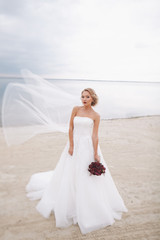 Fototapeta na wymiar Beautiful bride in wedding day on the coast.