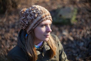 Portrait of young woman in knitted cap at city park