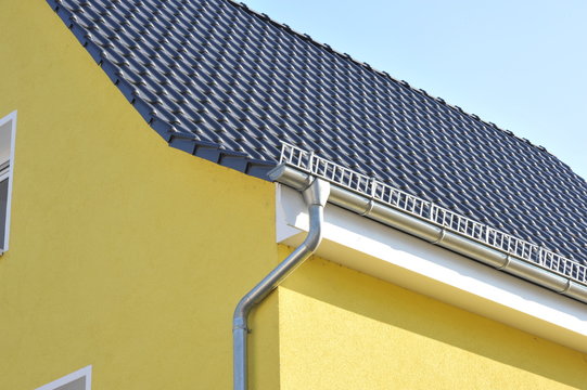 Dachrinne und Regenfallrohr an Gebaeude