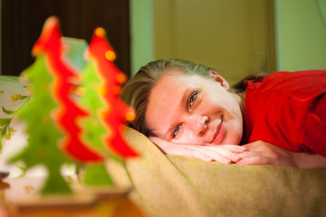 Young smiling woman sees on Xmas tree toys