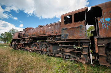 Fototapeta na wymiar Abandoned rusty steam locomotive.