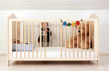 Ein Kleinkind an seinem Kinderbett