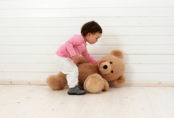 Ein Kleinkind spielt mit seinem Teddybären