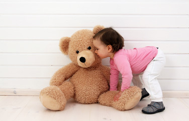 Ein Kleinkind spielt mit seinem Teddybären