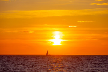 Naklejka na ściany i meble Beautiful orange sunset and boat on the Baltic sea