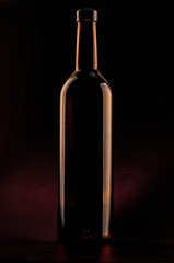 Bottle of wine, dark glass on the dark background 