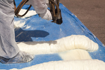 Technician spraying foam insulation using Plural Component Spray Gun