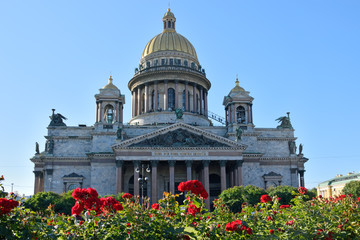 Fototapeta na wymiar St. Isaac's Cathedral on a background of red roses on the square