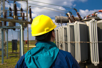 Technician with yellow helmet inspect high voltage power station