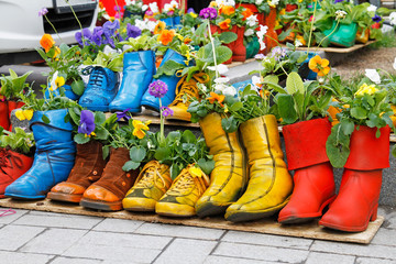 Colorful old boots used as flower pots.