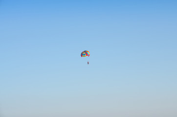 People on a parachute against a blue sky