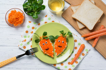 Funny toasts in a shape of carrots, food for kids Easter idea, top view
