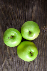 ripe green apples and apple slices on wooden gray background