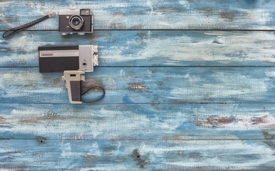 Video and photo camera on a blue old vintage blue background. Photographed in retro style
