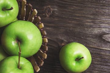 ripe green apples and apple slices on wooden gray background