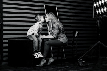Fototapeta na wymiar portrait of stylish cute little boy with beautiful mom in photo studio