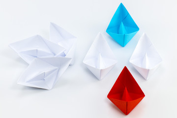 Leadership concept with red paper ship leading among white