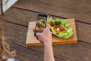 Photographer clicking a picture of food using smartphone