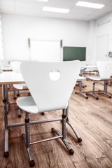 Chair and desk in empty classroom, closeup