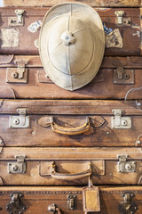 Pile of antique luggage suitcases with Salacot hat