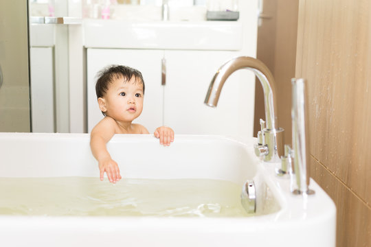 Asian Kid In The Bathroom With Bathtub