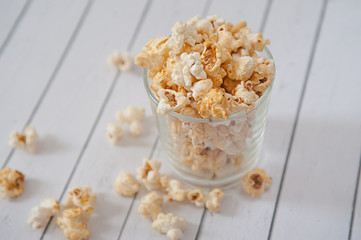 Popcorn in glass cup on white background