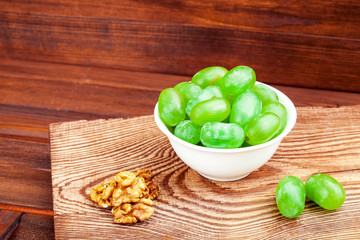 grape in white plate on wooden support.