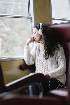 Teen passenger listening to the music traveling in a train