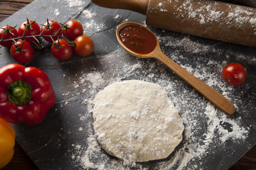 Preparing pizza with dough and tomato sauce